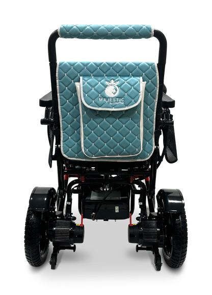 A teal quilted seat cover featuring a white Majestic logo adorns the backrest of the MAJESTIC IQ-7000 Remote Controlled Electric Wheelchair, which boasts black handlebars and large wheels. With a design inspired by lightweight wheelchairs, it offers both style and functionality against a plain background.