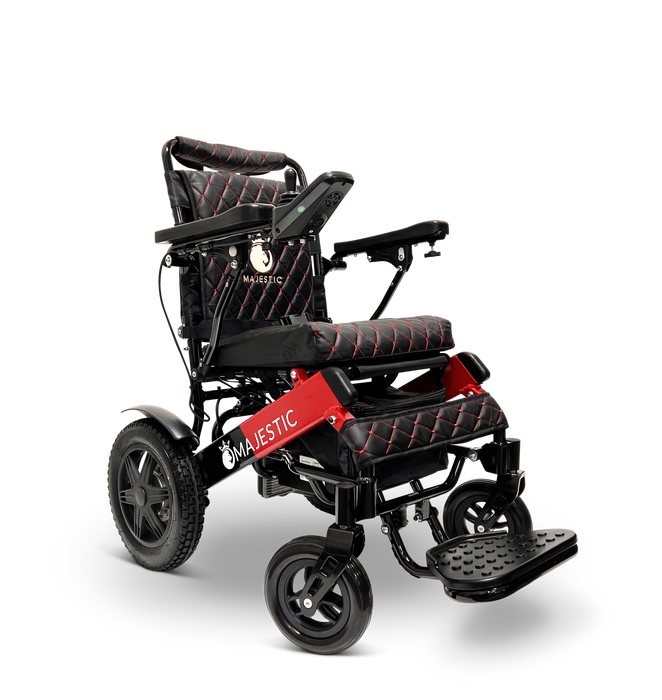 The ComfyGo MAJESTIC IQ-9000 Remote Controlled Electric Wheelchair, featuring a red and black color scheme with cushioned seats, is equipped with brushless silent motors and a digital joystick controller. Its design includes large rear wheels for stability, smaller front wheels for maneuverability, and displays the Majestic name on the frame.