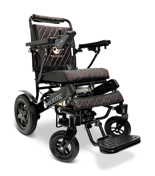 The ComfyGo MAJESTIC IQ-9000 Auto Folding Electric Wheelchair in black offers red-stitched padded seating and armrests, a digital joystick controller on the right armrest, brushless silent motors for seamless operation, a foldable frame, four wheels for easy mobility, and an integrated footrest.