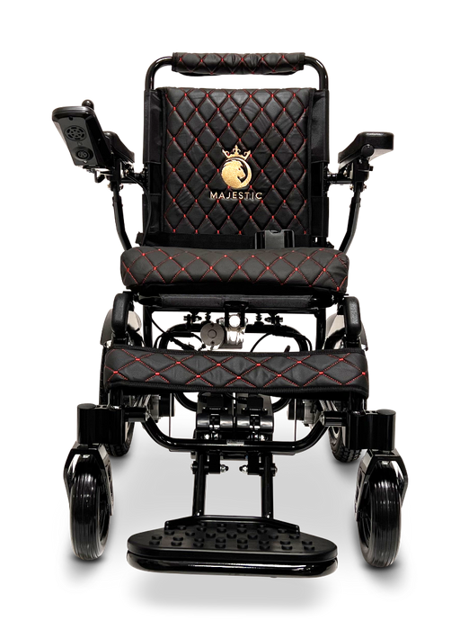 Introducing the ComfyGo MAJESTIC IQ-9000 Auto Folding Electric Wheelchair, a sleek black model featuring a quilted seat and backrest design with red stitching and an elegant gold logo. It comes equipped with brushless silent motors, armrests, and a digital joystick controller on the left arm for effortless navigation.