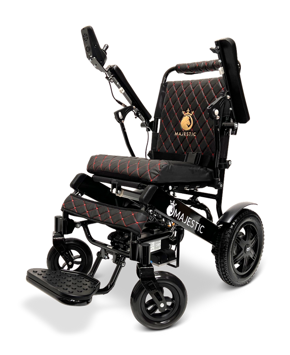 The ComfyGo MAJESTIC IQ-9000 Auto Folding Electric Wheelchair comes in black and red, featuring a quilted seat design and the word "Majestic" embroidered on the backrest. It includes an adjustable headrest, footrest, and rear wheels ideal for mobility assistance. This wheelchair is powered by brushless silent motors and operated with a digital joystick controller.