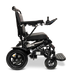 Side view of a foldable electric wheelchair with the brand name ComfyGo on its frame. The ComfyGo MAJESTIC IQ-9000 Auto Folding Electric Wheelchair features a digital joystick controller on the right armrest, padded seat, and large rear wheels with brushless silent motors and a small caster wheel at the front.