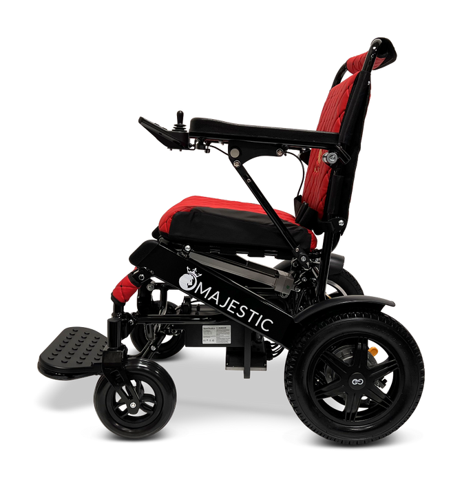 Side view of the ComfyGo MAJESTIC IQ-9000 Auto Folding Electric Wheelchair in red and black with a Majestic logo. It showcases large rear wheels, smaller front wheels, a cushioned seat, and foldable footrests for improved mobility and comfort. The wheelchair is powered by brushless silent motors and controlled via a digital joystick controller.