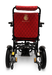 The rear view of the ComfyGo MAJESTIC IQ-9000 Auto Folding Electric Wheelchair reveals a red seat with a black frame, highlighted by quilted fabric and adorned with a gold crown logo featuring the word "Majestic" embroidered underneath. It is equipped with brushless silent motors, enhancing its sleek design, which includes wheels and footrests for smooth mobility.