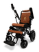 The sophisticated ComfyGo MAJESTIC IQ-9000 Auto Folding Electric Wheelchair showcases elegant black frames paired with brown quilted cushioning. It is equipped with a digital joystick controller, silent brushless motors, adjustable components, and an accommodating footrest. The MAJESTIC logo is prominently featured on both the frame and backrest.