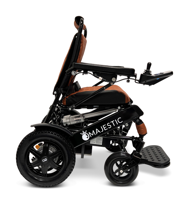 The ComfyGo MAJESTIC IQ-9000 Auto Folding Electric Wheelchair, presented in sleek black and orange, showcases a compact and modern design. It is powered by brushless silent motors for seamless operation and comes with large rear wheels. The wheelchair features an IQ-9000 AR digital joystick controller conveniently placed on the armrest and includes a practical footrest.