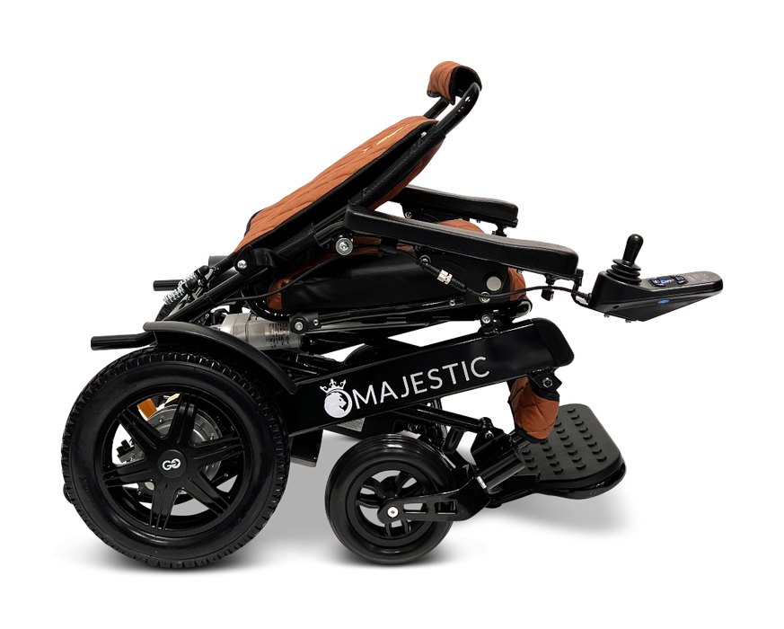 A black ComfyGo MAJESTIC IQ-9000 Auto Folding Electric Wheelchair featuring large rear wheels and a brown cushioned seat, shown from the side. Equipped with a digital joystick controller on the right armrest, this model is powered by brushless silent motors and includes front footrests to ensure optimal comfort.