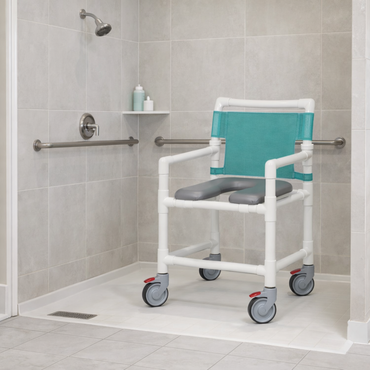 A shower room with tiled walls features the IPU Oversize Open Front Soft Seat Rolling PVC Shower Chair with armrests and teal backrest, offering heavy-duty support. Placed under the showerhead near grab bars, it ensures safe, accessible bathing.