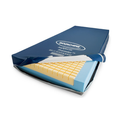 The Invacare Softform Premier Bariatric Pressure Relief Mattress features a blue cover, partially unzipped to show yellow and blue layered foam inside, designed to provide optimal support and pressure relief for bariatric users.