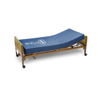 A hospital-style adjustable bed with a wooden headboard and footboard, shown partially elevated on wheels, features an Invacare Softform Premier Bariatric Pressure Relief Mattress in blue for mobility and optimal pressure relief.