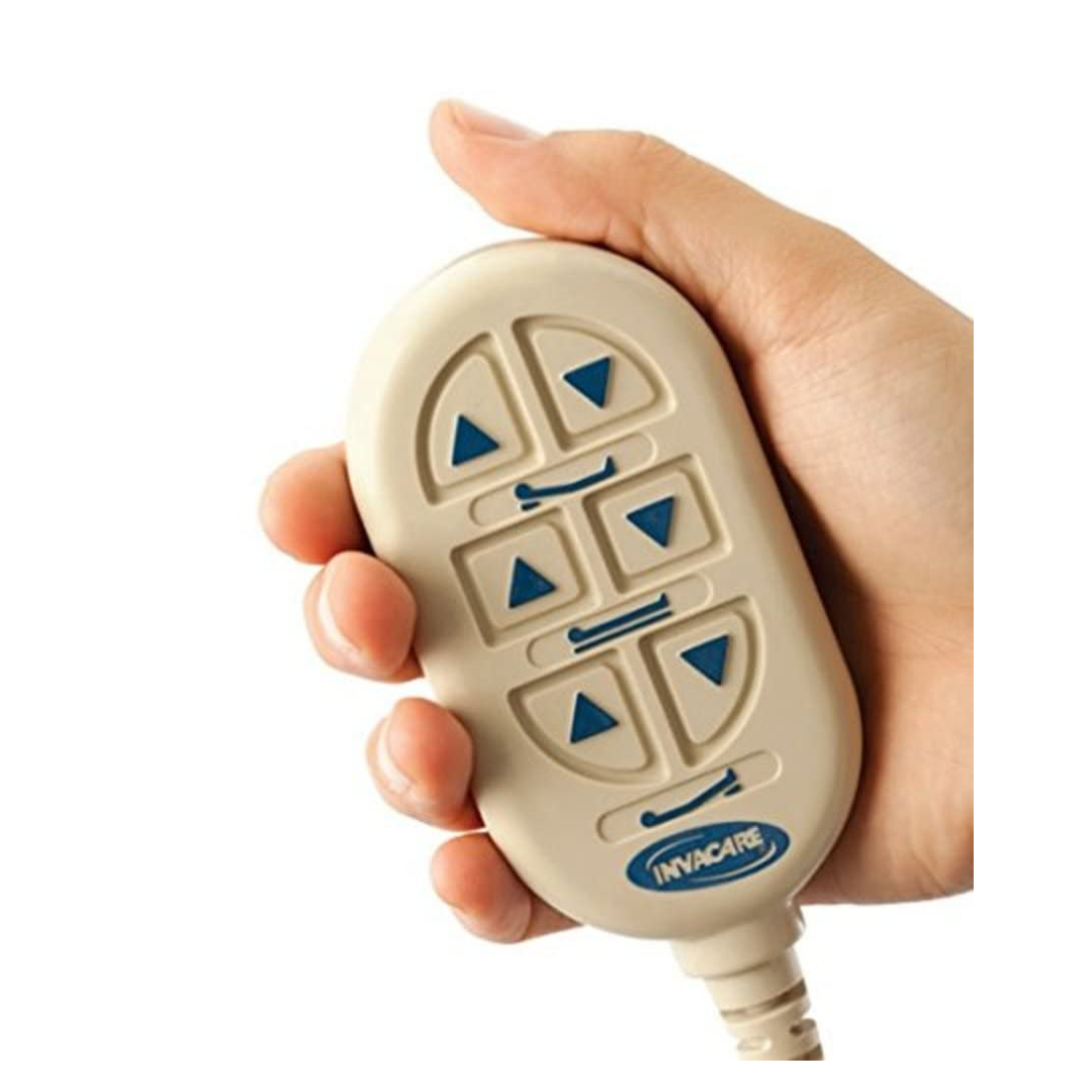 A hand holds an Invacare remote with blue arrow buttons and a beige casing, designed to adjust positions on Invacare Full-Electric Low Homecare & Hospital Beds.