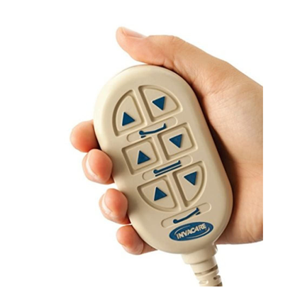 A hand holds an Invacare remote with blue arrow buttons and a beige casing, designed to adjust positions on Invacare Full-Electric Low Homecare & Hospital Beds.
