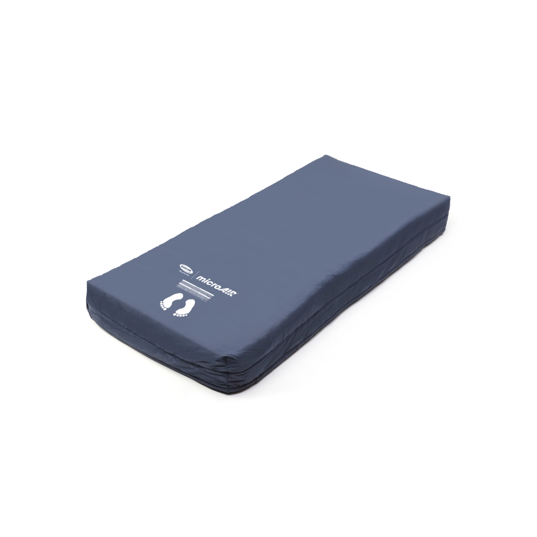 The Invacare microAIR® MA500 Alternating Pressure Low Air Loss Mattress System is a dark blue rectangular hospital mattress with a smooth surface, printed white footprints, and the brand name and logo on the cover for advanced pressure relief.