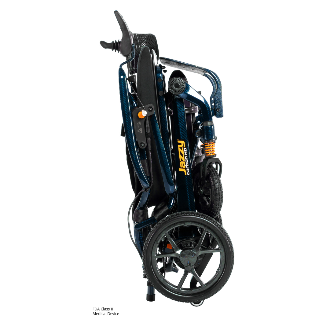 The Pride Jazzy Carbon HD Bariatric Portable Powerchair is a compact, foldable blue and black chair with visible wheels and handlebars, featuring Jazzy branding, designed for easy transport and storage.
