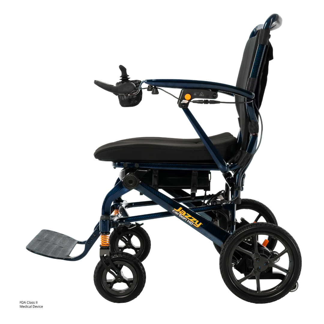 Side view of the Pride Jazzy Carbon HD Bariatric Portable Powerchair: lightweight, with a joystick on the armrest, black cushioned seat and backrest, large rear wheels, small front wheels, and a footrest—perfect for convenient travel mobility.
