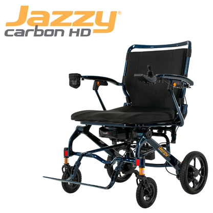 The Pride Jazzy Carbon HD Bariatric Portable Powerchair is a lightweight travel wheelchair with a black seat, armrests, cup holder, and large rear wheels. Its name appears in orange and gray at the top left for easy identification.