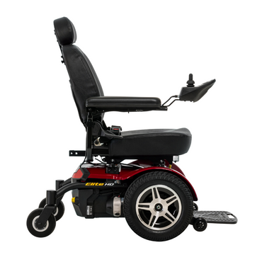 A side view of the Pride Mobility Jazzy® Elite HD Powerchair in red and black, featuring a padded seat, armrests, joystick control, large rear wheels, small front wheels, and a footrest.