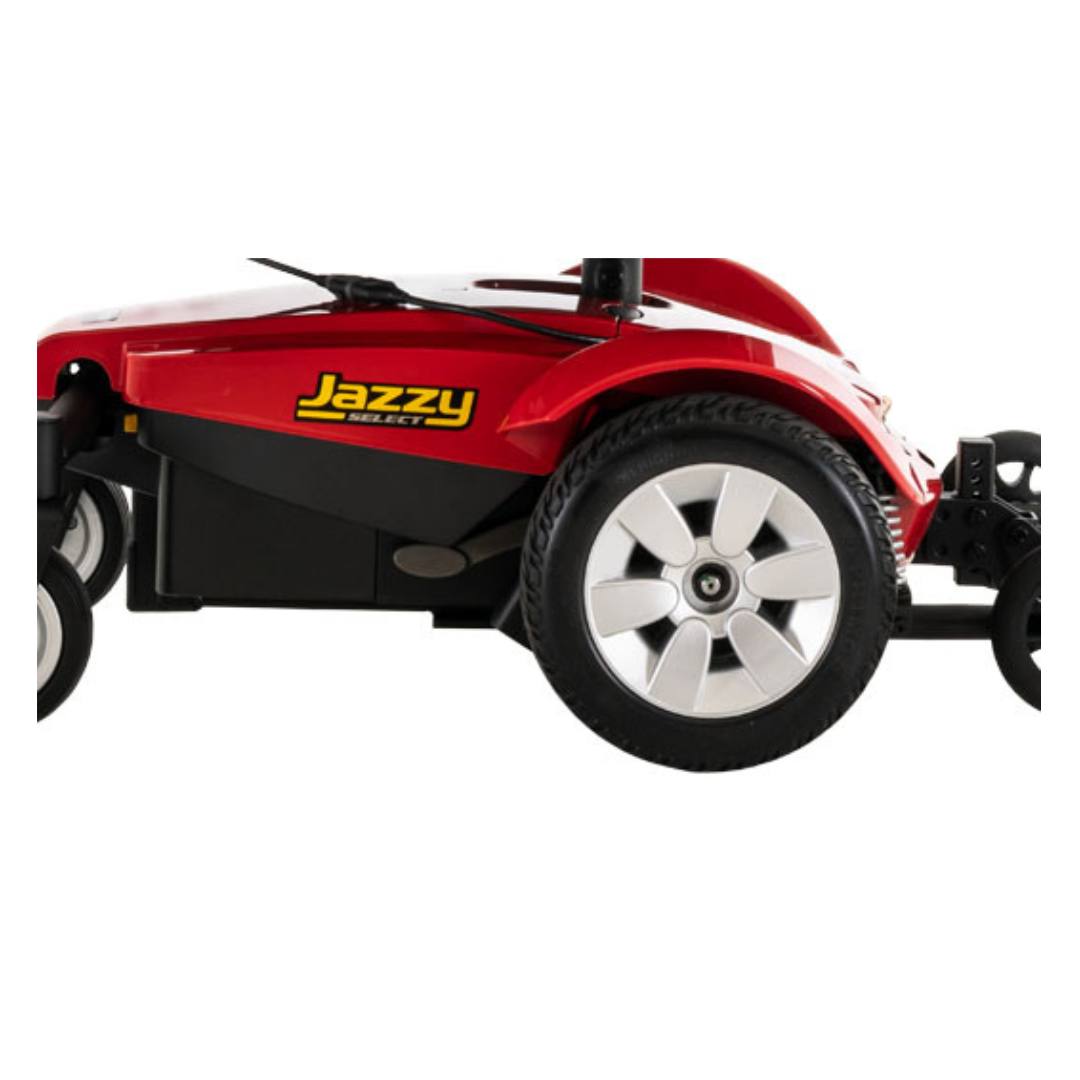 A close-up of the Pride Mobility Jazzy Select® Powerchair’s side showcases its detailed wheels and body, emphasizing the advanced mid-wheel drive design.