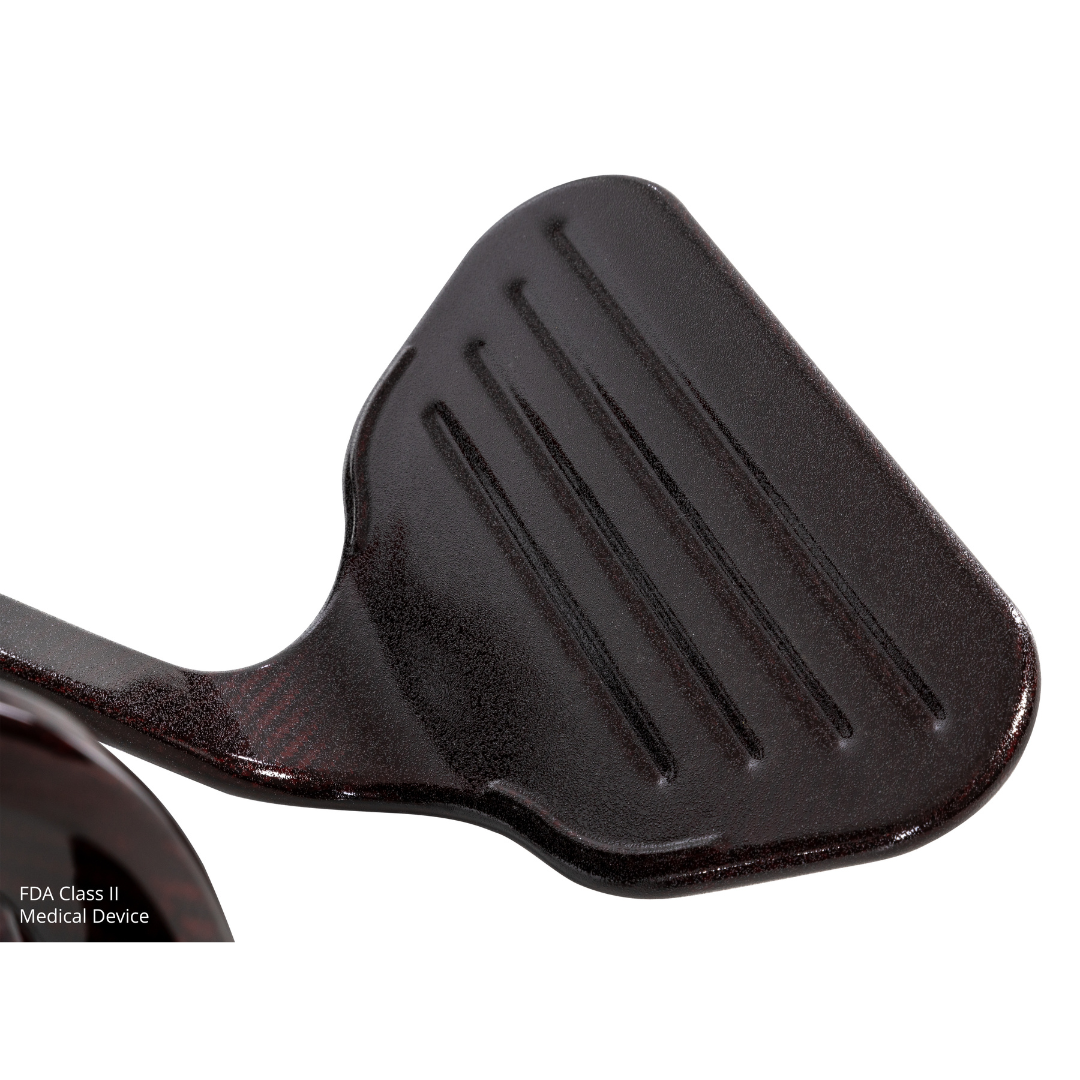 Close-up of a dark, textured pedal with horizontal grooves, likely from the Jazzy® Carbon 27 Ultralite Portable Power Wheelchair. "FDA Class II Medical Device" appears faintly in the lower left corner.