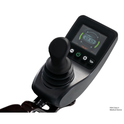Close-up of a black electronic joystick controller with a display showing battery and speed indicators, designed for the Jazzy® Carbon 27 Ultralite Portable Power Wheelchair.