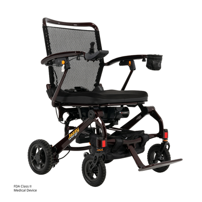 The Jazzy® Carbon 27 Ultralite Portable Power Wheelchair features a mesh backrest, padded seat, adjustable armrests, compact wheels, footrest, and cupholder. Text: “FDA Class II Medical Device.” Lightweight and foldable design.