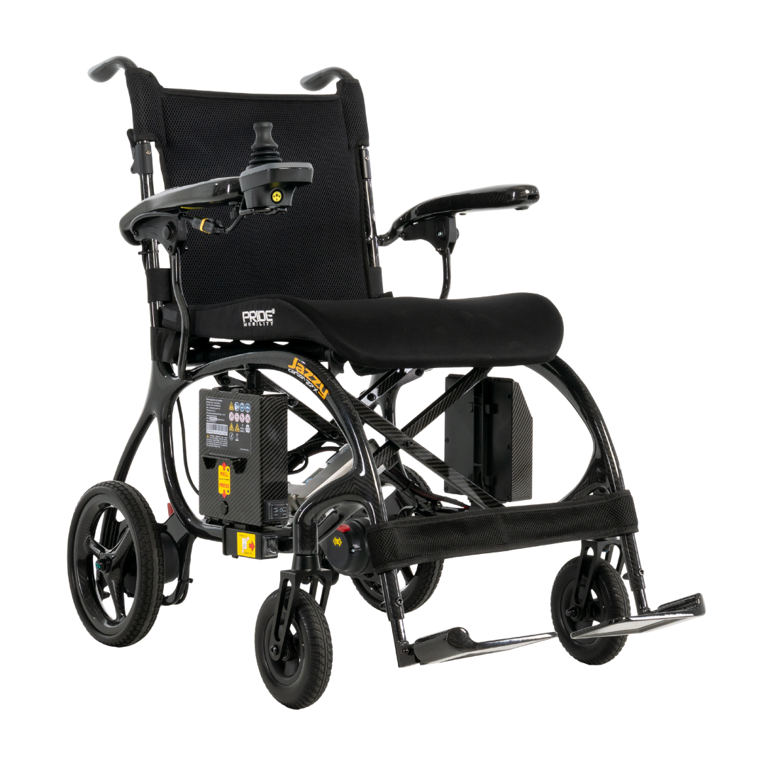 The Pride Jazzy® Carbon 27X Portable Power Wheelchair is a lightweight, black carbon fiber chair with a right-arm joystick, mesh backrest, padded seat, footrests, four wheels, and a battery pack attached to the frame.