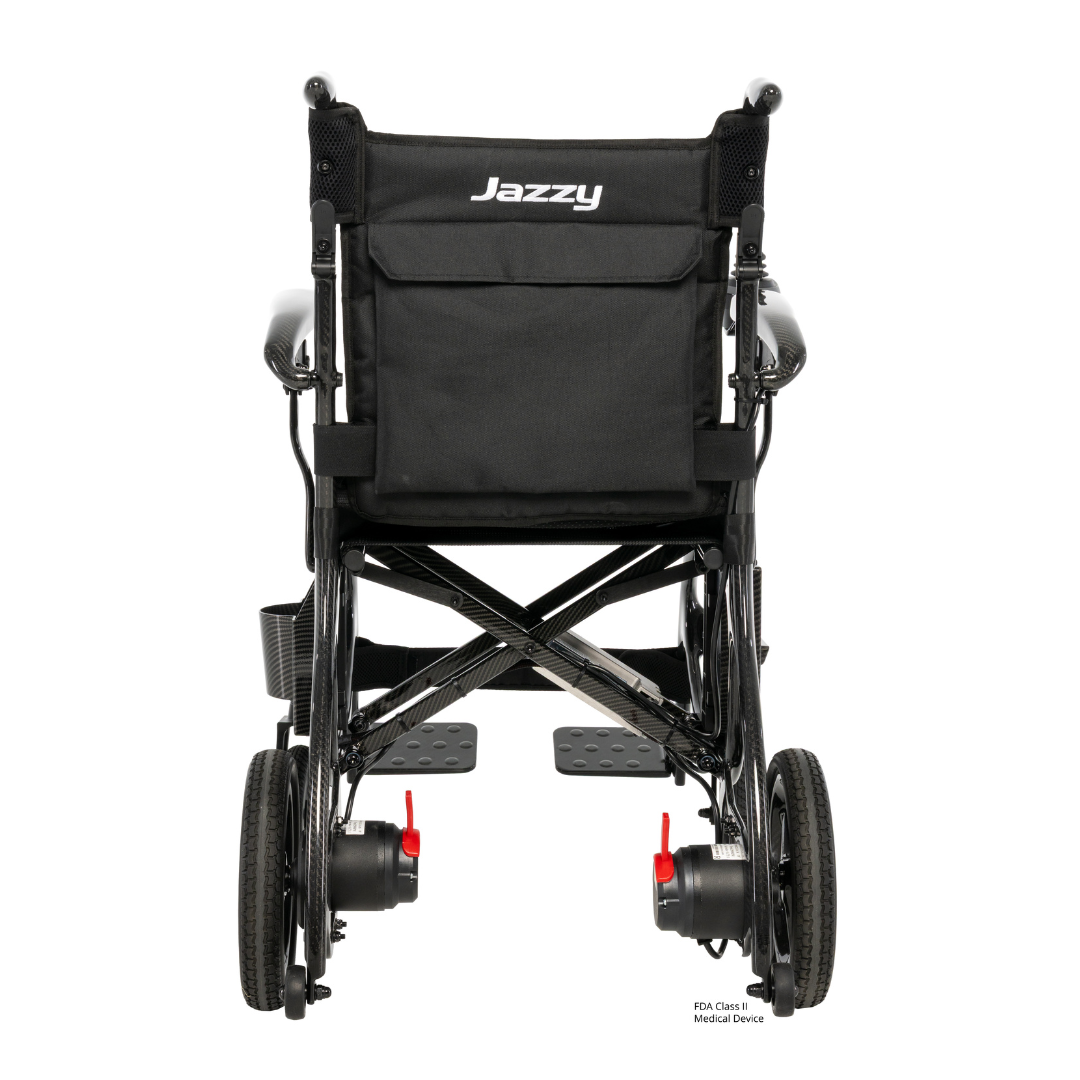 Rear view of the Pride Jazzy® Carbon 27X Portable Power Wheelchair in black, featuring a storage pocket on the backrest, large rear wheels, smaller front wheels, and red release levers near the wheels.