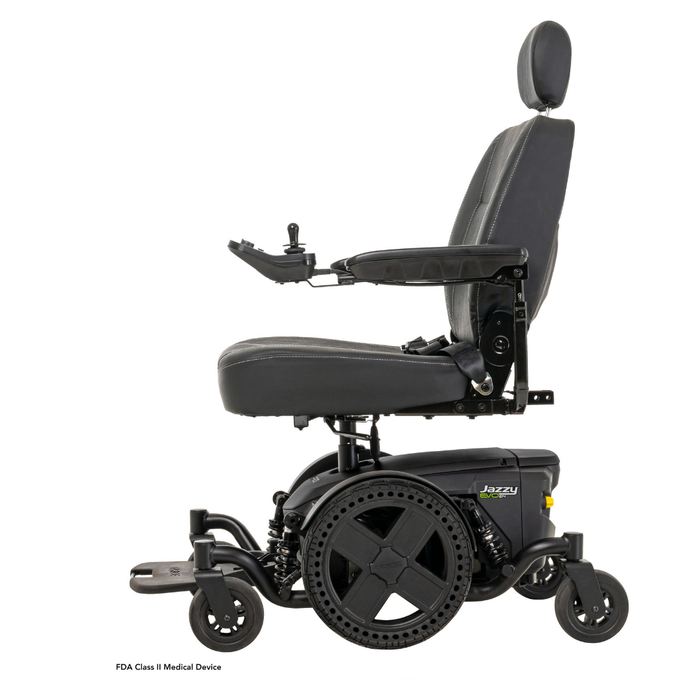 The Pride Mobility Jazzy® EVO 614 HD Bariatric Powerchair with ATX Suspension is shown in side profile on a white background. It features a black frame, cushioned seat, adjustable armrests, headrest, joystick control, and large rear wheels.