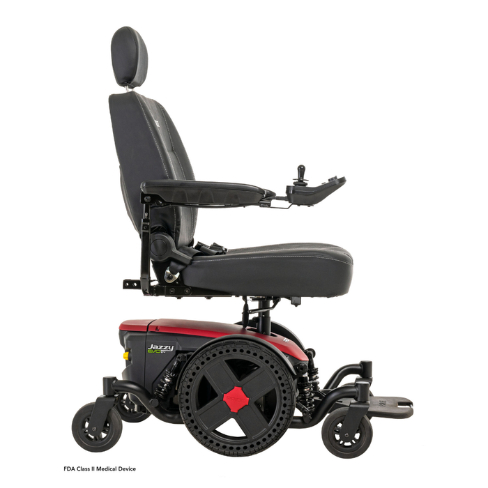 A side view of the Pride Mobility Jazzy® EVO 614 HD Bariatric Powerchair with ATX Suspension, in black and red, featuring a cushioned seat with headrest, armrests, right-side joystick control, and four heavy-duty wheels.