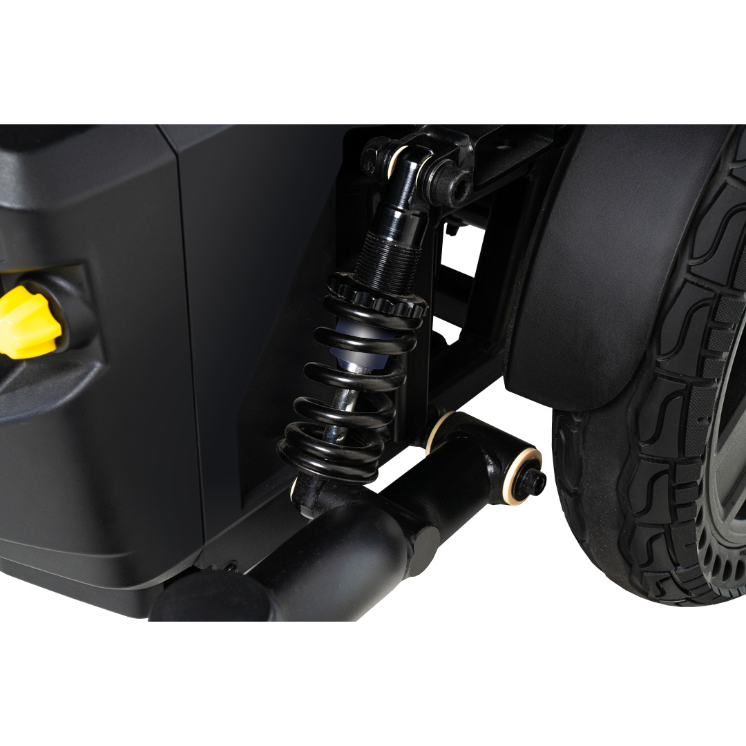 Close-up of the black suspension spring and wheel on the Pride Mobility Jazzy® EVO 614 HD Bariatric Powerchair with ATX Suspension, featuring a yellow knob and highlighting its shock absorber and tire tread for enhanced comfort.