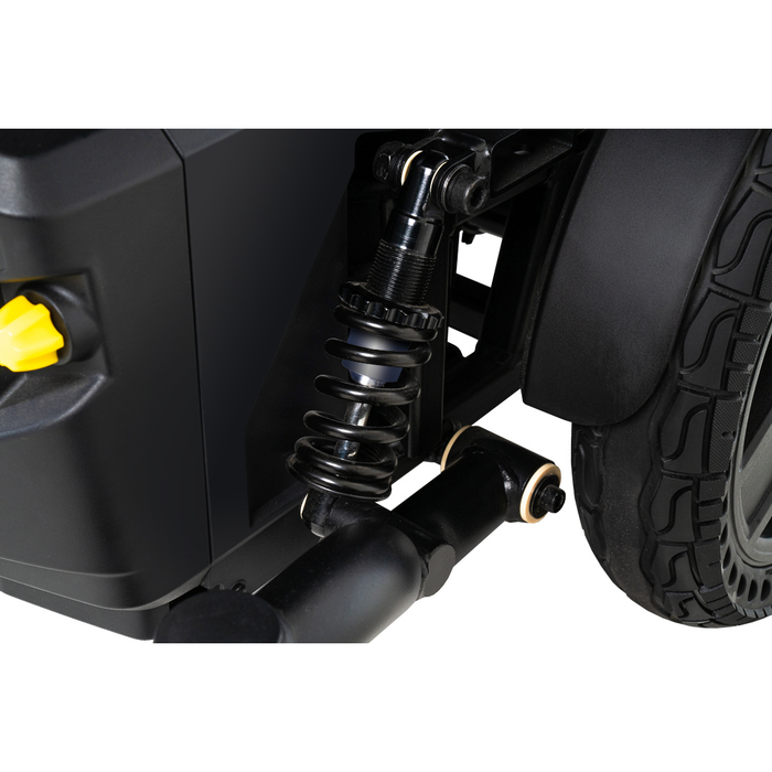 Close-up of the black suspension spring and wheel on the Pride Mobility Jazzy® EVO 614 HD Bariatric Powerchair with ATX Suspension, featuring a yellow knob and highlighting its shock absorber and tire tread for enhanced comfort.