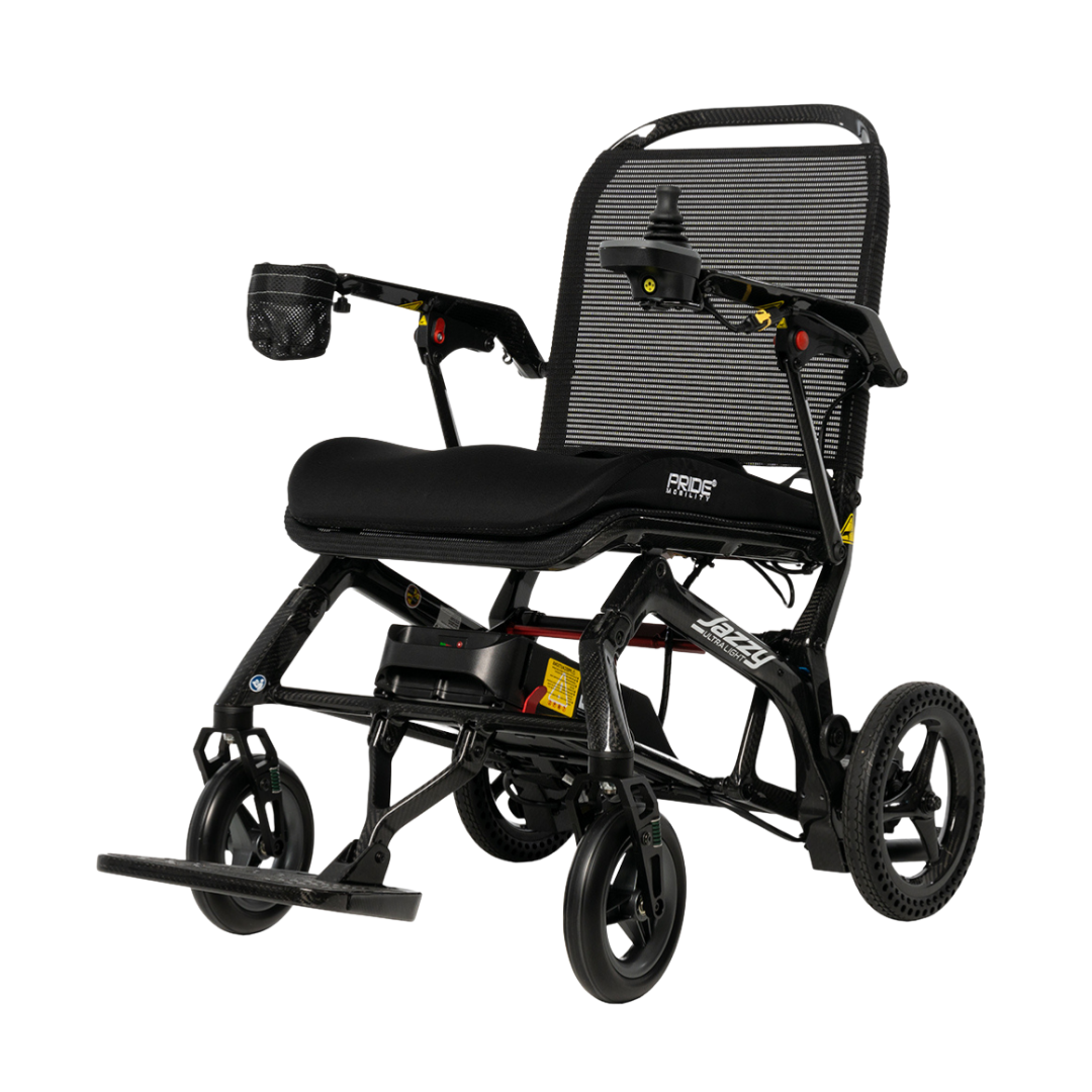 The Pride Mobility Jazzy® Ultra Light Portable Electric Wheelchair is a lightweight black chair with a mesh backrest, padded seat, footrest, joystick controller, small front and large rear wheels, plus an armrest storage pouch.