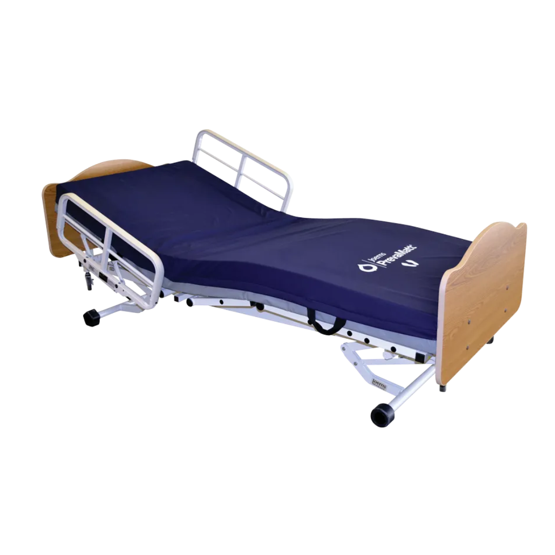 The Joerns WeCare® Full-Electric Hi/Low Bariatric Homecare Bed with wooden head and foot boards, white metal side rails, a dark blue mattress, and ultra-low adjustable height for fall prevention is shown against a white background.