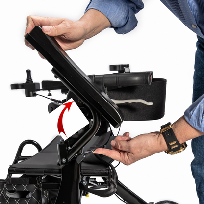 A person adjusts the backrest angle of the Journey Air Elite Max Ultralite Carbon Fiber Travel Powerchair using a lever with an arrow showing the direction. The side view highlights arm supports on this comfortable mobility chair.