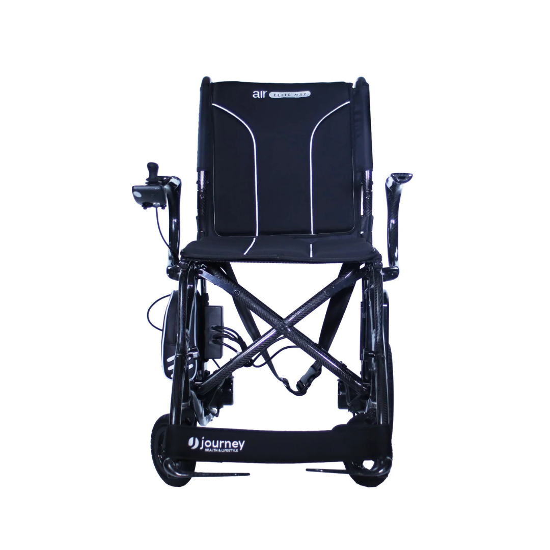 The Journey Air Elite Max Ultralite Carbon Fiber Travel Powerchair is a black, comfortable wheelchair with left-arm joystick control, cushioned seat and backrest, “Air Journey” on the back, and “Journey” on the footrest against a white background.