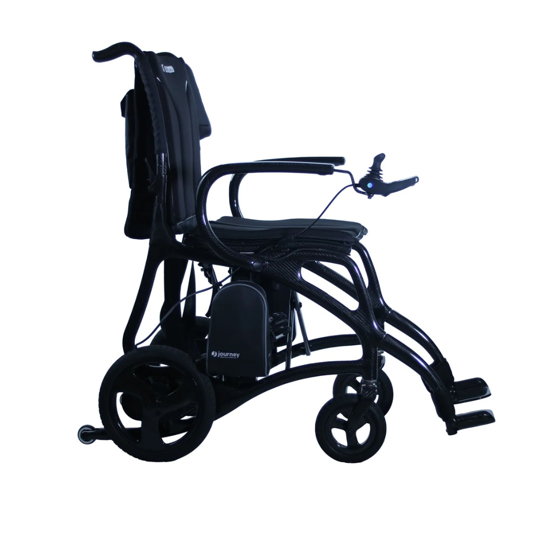 The Journey Air Elite Max Ultralite Carbon Fiber Travel Powerchair is a black, lightweight electric wheelchair featuring right-arm joystick control, footrests, large rear wheels, and a supportive backrest, shown against a white background.