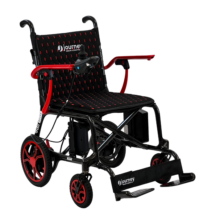 Discover the Journey Air Elite Folding Lightweight Powerchair, weighing just 29 lbs. It boasts a chic black and red design with four wheels, footrests, armrests, a check-patterned backrest, and right-armrest joystick control for smooth indoor navigation. The brand logo adorns both the seat and footrest.