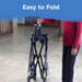 A person in a red sweater demonstrates folding a black Journey UPWalker® Original Upright Rolling Walker Rollator at home, with Easy to Fold text atop. This tool provides upright walking support for those with mobility challenges.