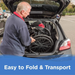 An elderly man loads a folded Journey So Lite® C2 Ultra Lightweight Wheelchair, crafted from military-grade magnesium, into a cars trunk. A blue banner at the bottom reads Easy to Fold & Transport, highlighting its unmatched mobility.