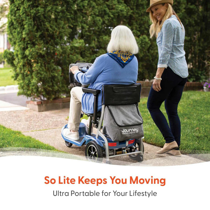 A woman assists an elderly person using a Journey So Lite® Folding Power Scooter on a park path, featuring electronic anti-tip technology. Text below reads So Lite Keeps You Moving - Ultra Portable for Your Lifestyle, set against a backdrop of trees and greenery.