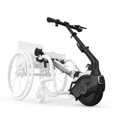 A black Klaxon® Twist Mobility Power-Assist Hub | Wheelchair Power Assist is attached to the front of a white lightweight manual wheelchair, with the power assist device clearly visible.