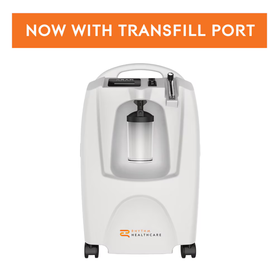 The Rhythm LM5BA 5L Stationary Oxygen Concentrator, in white with a clear canister and the Rhythm Healthcare logo, features a prominent orange "NOW WITH TRANSFILL PORT" banner—perfect for at-home oxygen therapy.