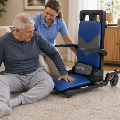 A caregiver assists an older man on the floor in using the Lift Buddy Motorized Floor to Seat Fall Recovery Patient Lift Chair in a softly lit living room with neutral decor.