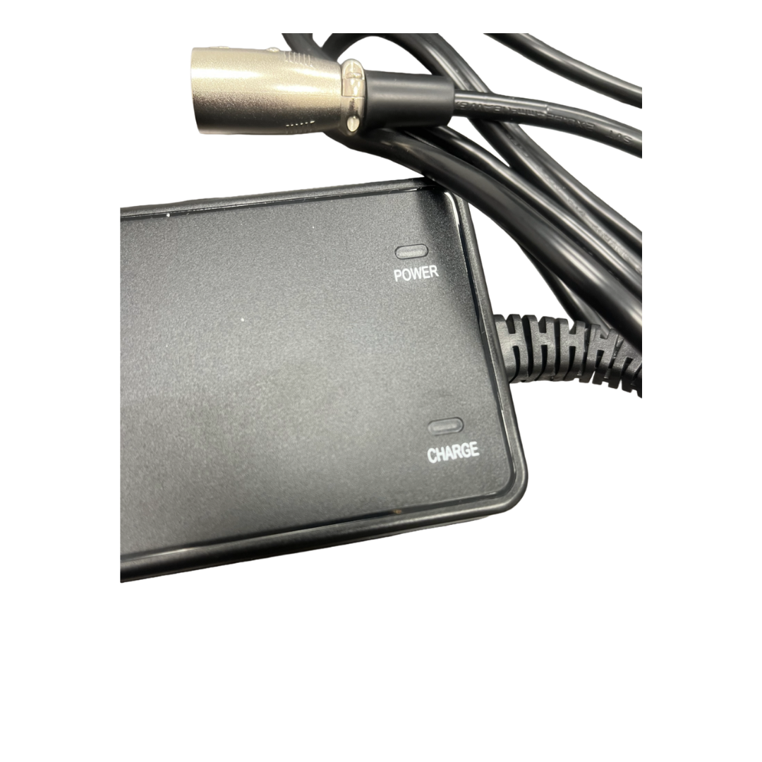 Close-up of a black electronic device, the Lithium Battery Charger 2AH - Monarch Mobility, featuring visible POWER and CHARGE indicator lights. Several black cables and a silver connector are shown near the top of the image, highlighting its compatibility as a lithium battery charger.