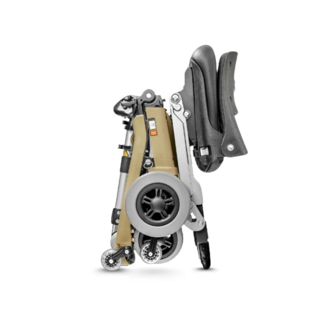 The FreeRider Luggie Standard Travel Scooter, with black seat cushions and a silver frame, stands upright folded on a white background, featuring large rear wheels and small front wheels for portable mobility.