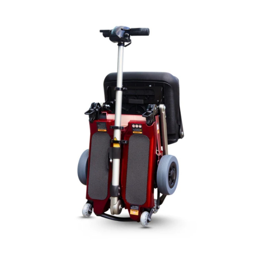 The FreeRider Luggie Standard Travel Scooter is a compact, lightweight red scooter with a black seat and gray wheels, shown folded for easy transport or storage as a portable mobility scooter against a white background.