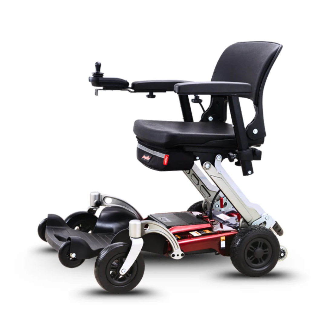 The FreeRider Luggie Travel Lightweight Powerchair features a black seat, armrests, right-arm joystick control, four wheels, and a foldable metallic frame with red and black accents for easy storage and transport.