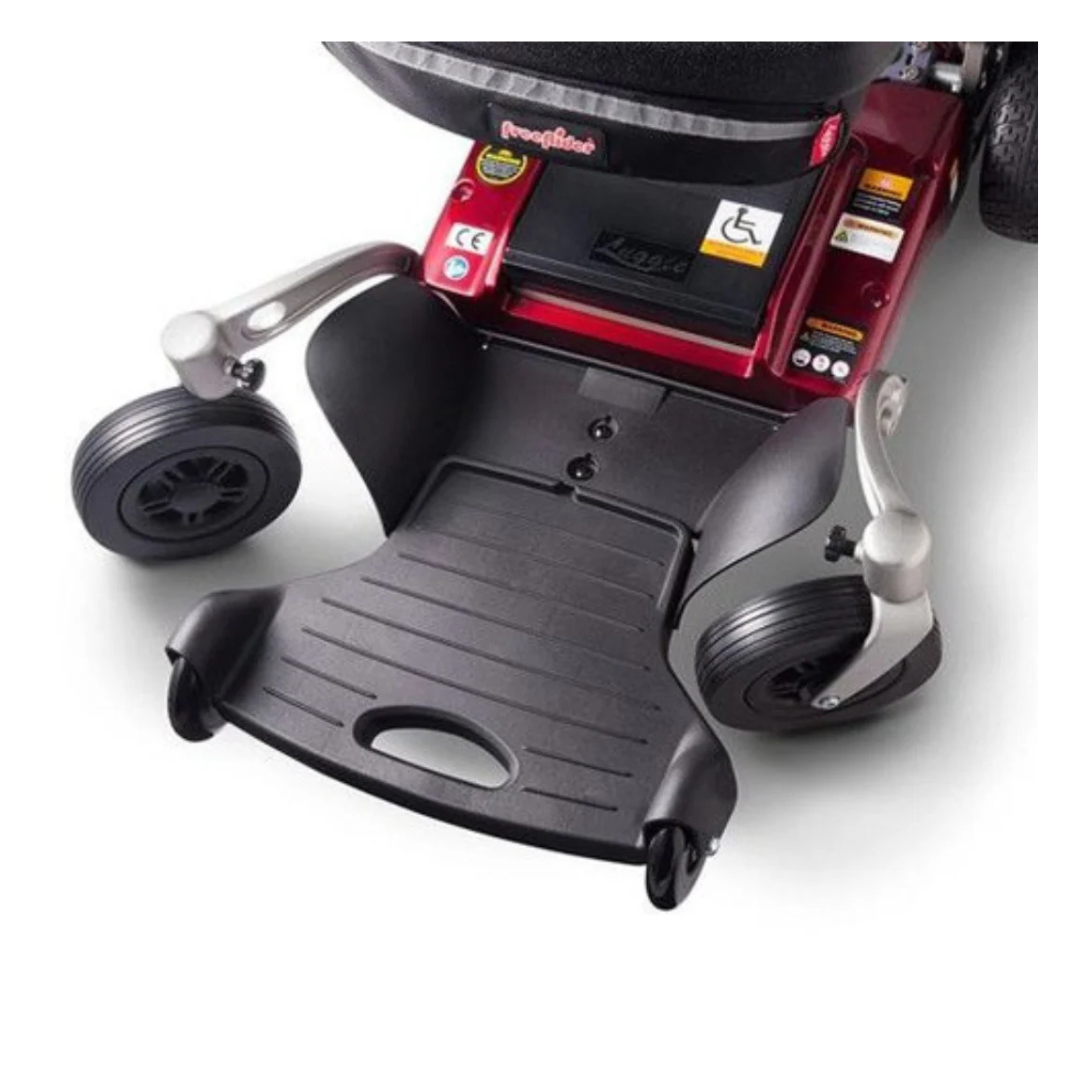 Close-up view of the footrest and front wheels of the FreeRider Luggie Travel Lightweight Powerchair in red, showing accessibility stickers and part of the seat above.