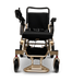 The MAJESTIC IQ-7000 Auto Folding Remote Controlled Electric Wheelchair, in gold and black, stands out against a dark backdrop. It includes a 360-degree joystick on the right armrest and sturdy footplates for comfort and control.