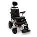 The ComfyGo MAJESTIC IQ-9000 is a modern electric wheelchair with black and gold quilted padding, auto-reclining function, headrest, armrests, and footrest. It has a metallic frame with a digital joystick controller and brushless silent motors for stability on solid wheels.